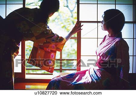 Stock Image - Two Young Woman Wearing A Yukata. Fotosearch