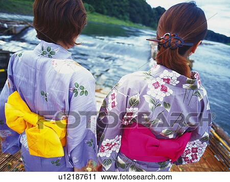 Stock Image - Two Young Woman Wearing A Yukata. Fotosearch