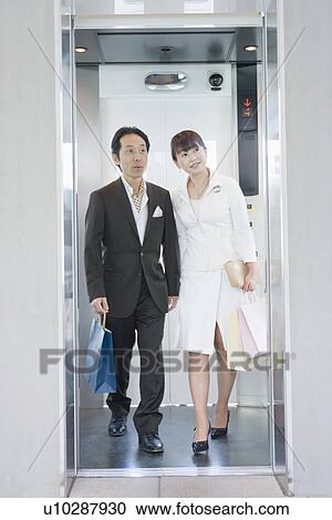 Stock Image - Japanese Couple, Go Down The Elevator. Fotosearch