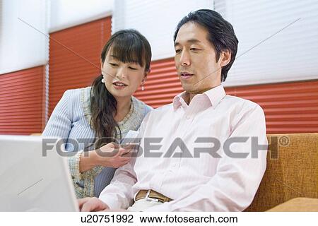Japanese Couple, Looking At Pc View Large Photo Image Stock Image - Japanese Couple, Looking At Pc. Fotosearch