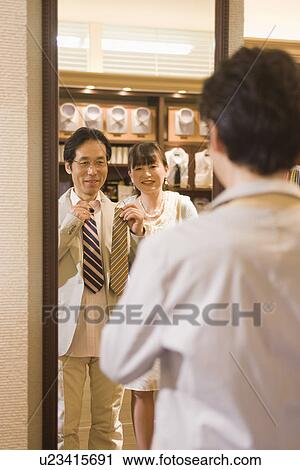 Stock Image - Japanese Couple Trying On Tie. Fotosearch