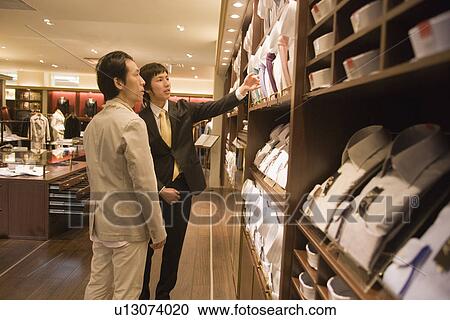 Stock Image - Japanese Man Looking Of Shirts. Fotosearch