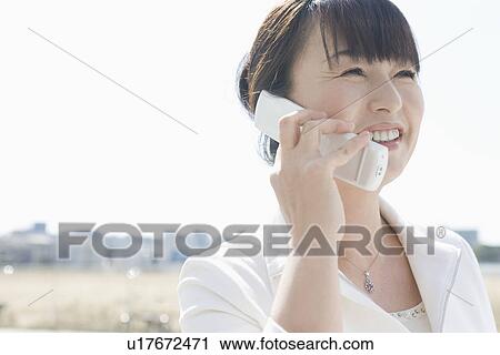 Stock Image - Japanese Woman On The Phone. Fotosearch