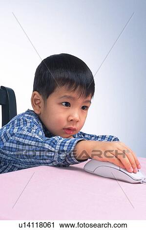 Stock Image -  a Little Boy Using a Computer Mouse, Side View. Fotosearch