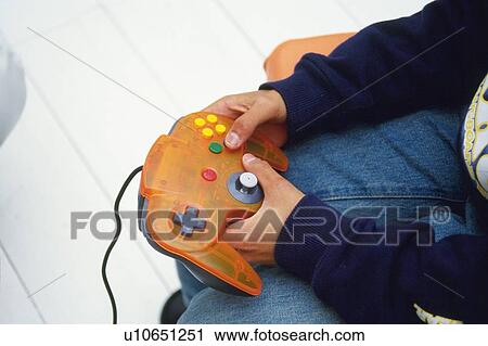 Stock Image -  a Little Child's Hand Holding a Video Game Controller, High Angle View. Fotosearch