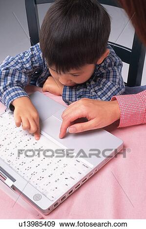 a Mother applying her little son how to use a laptop, High Angle View View Large Photo Image Stock Photo - a Mother applying her little son how to use a laptop, High Angle View. Fotosearch