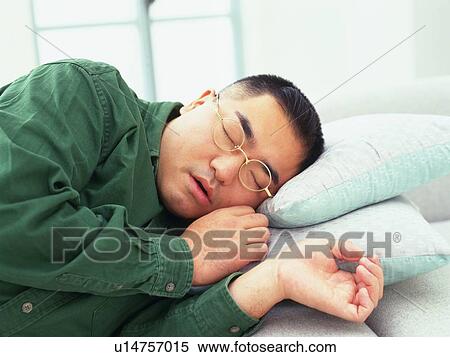Stock Photography -  an Adult Man taking a nap on the sofa, Differential Focus, Front View. Fotosearch