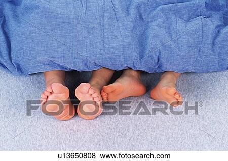 an Adult's and a child's Feet out of the Top of a Blue Blanket, High Angle View View Large Photo Image Stock Photo - an Adult's and a child's Feet out of the Top of a Blue Blanket, High Angle View. Fotosearch