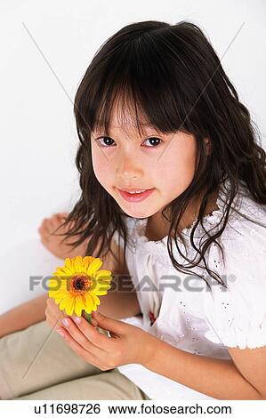 Girl holding a single yellow flower, Smiling, Looking at Camera, High Angle View, Differential Focus View Large Photo Image Stock Photograph - Girl holding a single yellow flower, Smiling, Looking at Camera, High Angle View, Differential Focus. Fotosearch