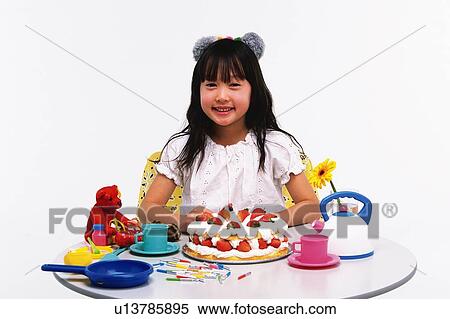 Little Girl sitting at table with birthday cake and kitchenware, looking at camera, Smiling, Front View View Large Photo Image Stock Photography - Little Girl sitting at table with birthday cake and kitchenware, looking at camera, Smiling, Front View. Fotosearch