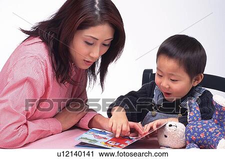Stock Image - Mother and her Little son reading a picture book together, High Angle View. Fotosearch