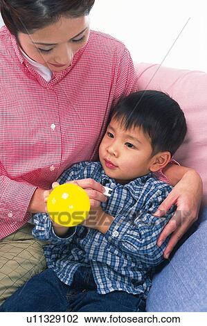Mother checking the temperature of her son who is holding a yellow ball, High Angle View View Large Photo Image Stock Image - Mother checking the temperature of her son who is holding a yellow ball, High Angle View. Fotosearch