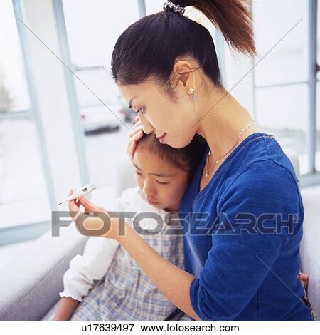 Stock Photo - Mother holding daughter's head, Checking for Fever With a Thermometer, Side View, Differential Focus. Fotosearch