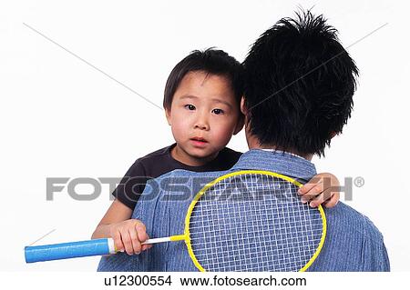 Picture - Portrait of a Little boy holding a racket, being Carried By his father, Front View, Rear View. Fotosearch