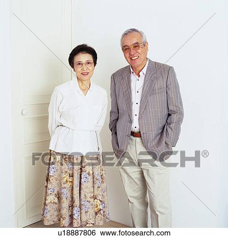 Portrait of a Senior Couple Standing In Front of a White door, Looking at Camera, Smiling, Front View View Large Photo Image Stock Photograph - Portrait of a Senior Couple Standing In Front of a White door, Looking at Camera, Smiling, Front View. Fotosearch