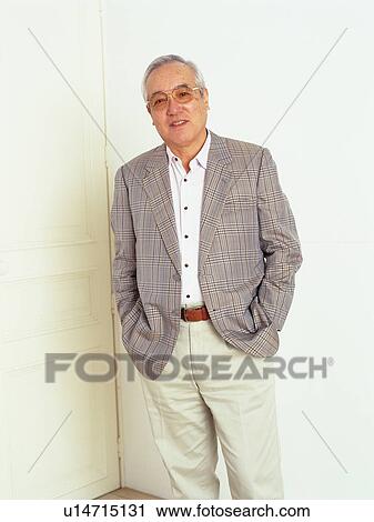 Senior man standing in front of white door with hands in his pocket, looking at camera, Smiling, Front View View Large Photo Image Stock Image - Senior man standing in front of white door with hands in his pocket, looking at camera, Smiling, Front View. Fotosearch