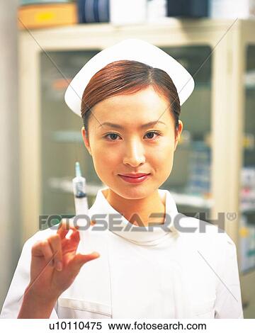 Close-up front view of a nurse holding syringe  View Large Photo Image Stock Photography - Close-up front view of a nurse holding syringe . Fotosearch
