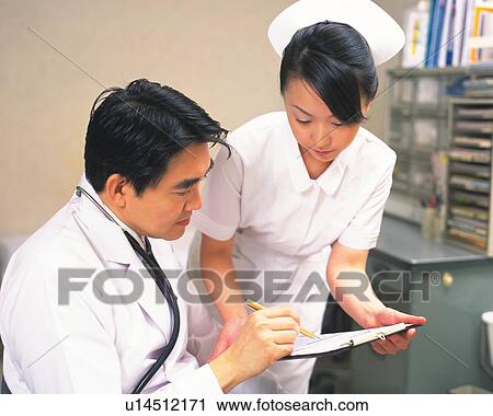 Doctor and nurse examining a clipboard, View Large Photo Image Stock Image - Doctor and nurse examining a clipboard, . Fotosearch