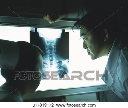 Stock Image - Doctor and nurse examining an x-ray. Fotosearch