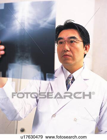 Stock Photo - Doctor examining an x-ray. Fotosearch