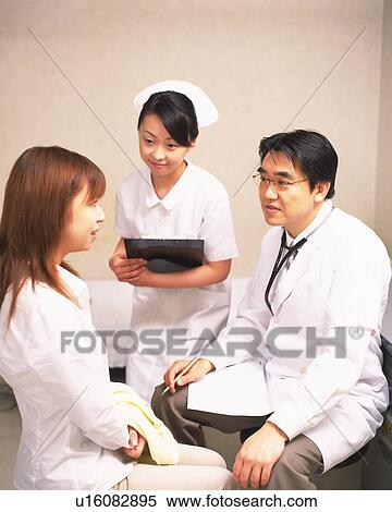 Doctor examining patient, nurse standing nearby, watching View Large Photo Image Stock Photography - Doctor examining patient, nurse standing nearby, watching. Fotosearch