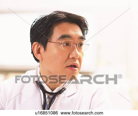 Stock Photograph - Male doctor examining a patient. Fotosearch