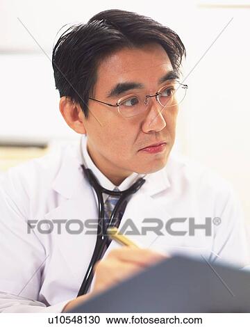 Male doctor writing on a clipboard View Large Photo Image Stock Image - Male doctor writing on a clipboard . Fotosearch