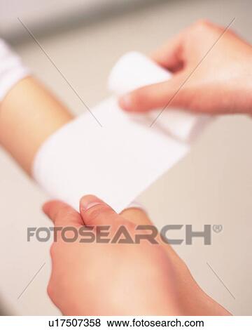 Stock Photo - Nurse bandaging a patient's arm, close-up. Fotosearch