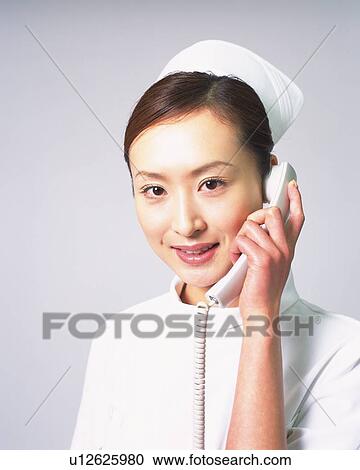 Stock Image - Nurse on the telephone, portrait. Fotosearch
