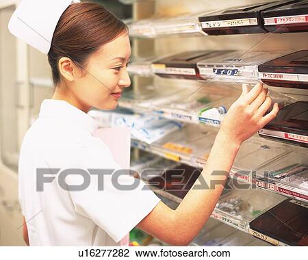 Nurse taking a surgical equipment from a shelf View Large Photo Image Stock Image - Nurse taking a surgical equipment from a shelf. Fotosearch