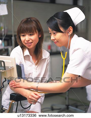 Nurse taking male patient's blood pressure View Large Photo Image Stock Photograph - Nurse taking male patient's blood pressure . Fotosearch
