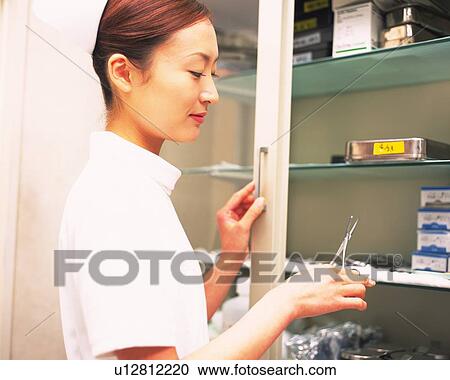 Nurse taking scissors from a surgical equipment of shelf View Large Photo Image Stock Image - Nurse taking scissors from a surgical equipment of shelf. Fotosearch