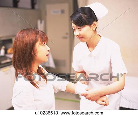 Stock Image - Patient getting injured hand bandaged . Fotosearch