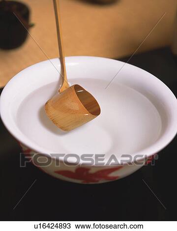 Stock Image - Bamboo dipper scooping hot water from tea cup for tea ceremony, high angle view, close up, Japan, differential focus. Fotosearch
