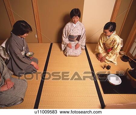 Stock Image - Four women attending Japanese tea ceremony, high angle view, Japan. Fotosearch