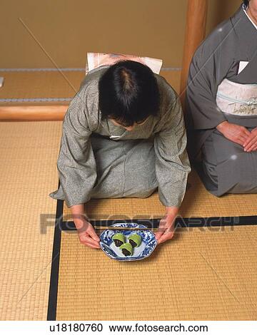 Stock Image - Two women sitting on Tatami mat in a tea room, high angle view, Japan. Fotosearch