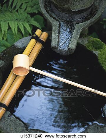 Stock Image - Water filled in stone basin in Japanese garden, Japan, high angle view. Fotosearch