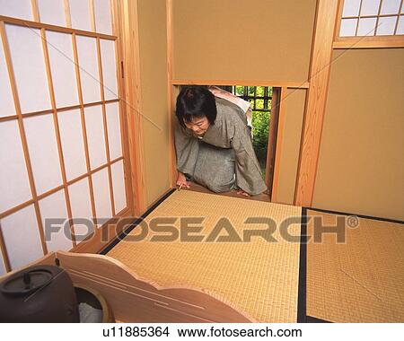 Picture - Woman in kimono entering into the tea room from Nijiriguchi, front view, Japan. Fotosearch