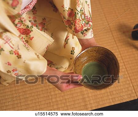 Stock Photography - Woman in kimono holding a tea cup at tea ceremony, high angle view, Japan. Fotosearch