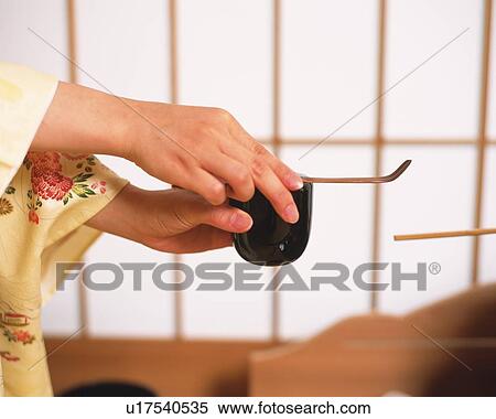 Stock Photography - Woman in kimono holding a tea spoon and a tea powder container, side view, Japan, differential focus. Fotosearch
