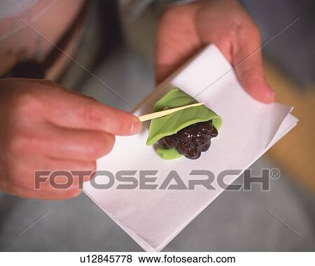 Stock Photo - Woman in kimono holding shi on paper, high angle view, close up, Japan, differential focus. Fotosearch