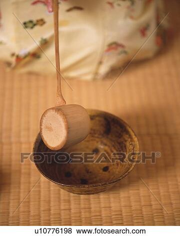 Stock Photo - Woman in kimono pouring hot water in Japanese tea cup at tea ceremony, high angle view, Japan, differential focus. Fotosearch