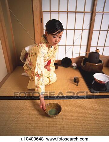 Stock Photo - Woman in kimono serving a cup of tea at tea ceremony, high angle view, Japan. Fotosearch