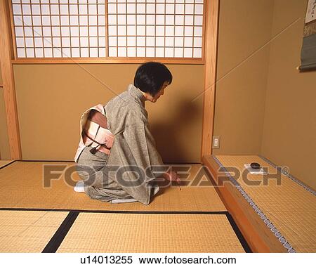 Stock Photography - Woman in kimono sitting on Tatami mat, side view, Japan. Fotosearch
