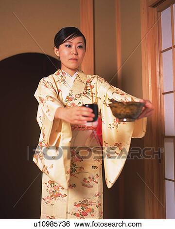 Woman in kimono standing and holding Japanese cups in a tea room, front view, Japan View Large Photo Image Stock Photograph - Woman in kimono standing and holding Japanese cups in a tea room, front view, Japan. Fotosearch