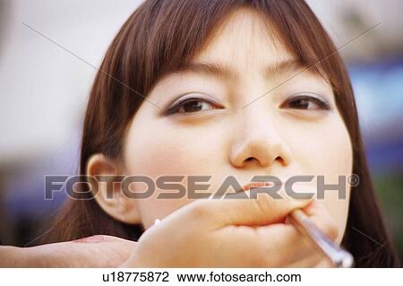Person applying makeup to young woman's lip, close-up View Large Photo Image Stock Image - Person applying makeup to young woman's lip, close-up . Fotosearch
