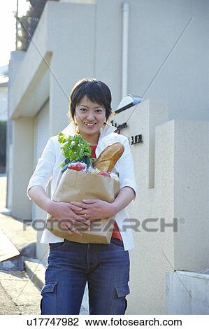 Stock Image - Portrait of a woman carrying groceries, portrait. Fotosearch