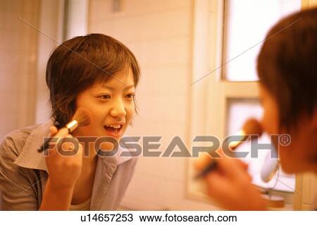 Woman applying make-up in the bathroom View Large Photo Image Stock Image - Woman applying make-up in the bathroom . Fotosearch