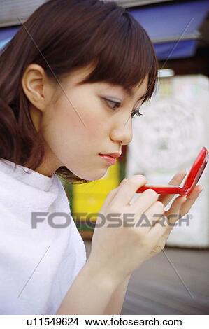 Picture - Woman using compact . Fotosearch