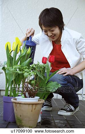 Stock Image - Young woman gardening outdoors . Fotosearch